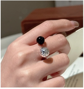 Détail macro d'une bague ajustable en argent avec perle d'onyx noire et bille facettée