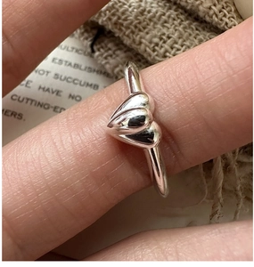 Macro shot of S925 sterling silver ring featuring polished double heart design detail