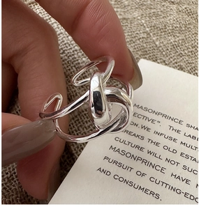 Close-up of S925 sterling silver multilayer twisted knot ring on a model's finger