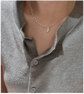 Dettaglio del ciondolo a chicco in argento S925 su collana minimalista di cristallo