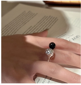 Détail d'une bague en argent 925 avec une sphère facettée et une perle d'onyx noire