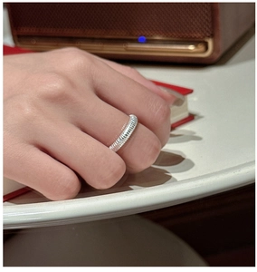 Vue détaillée d'une bague en argent sterling S925 à texture mate sur le doigt du mannequin