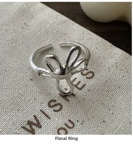 Close-up of vintage S925 sterling silver flower ring on a textured fabric pouch