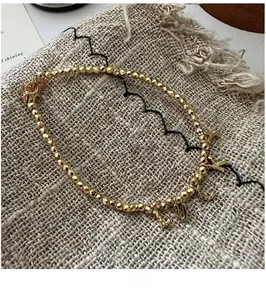 Detail of S925 silver beaded bracelet featuring gold LUCKY charms on linen fabric
