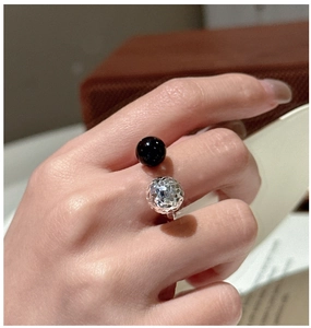 Détail d'une bague ouverte en argent 925 avec perle noire et sphère facettée minimaliste