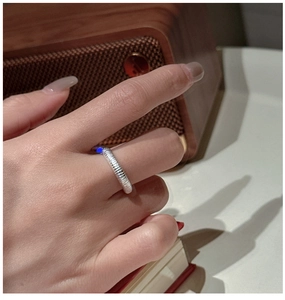 Vue détaillée d'une bague en argent S925 à texture mate portée au doigt