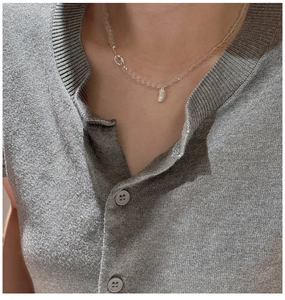 Dettaglio del ciondolo a fagiolo d'argento e perline di cristallo su una collana