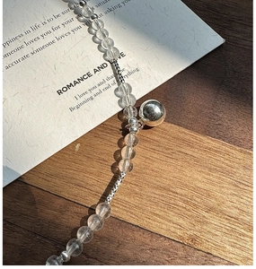 Detailed view of S925 silver beaded necklace with white crystals and polished metal ball