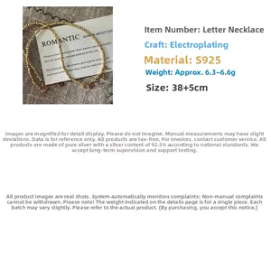 Detail of S925 sterling silver beaded chain necklace with golden letter pendant
