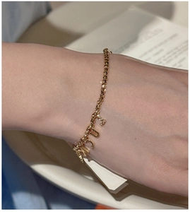 Detailed close-up of S925 silver gold-plated beaded bracelet with alphabet letter charms