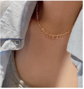 Detail of S925 silver beaded necklace with LUCKY letter charms on a model's neck