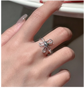 Close-up of a minimalist S925 sterling silver floral ring worn on the index finger
