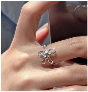 Macro shot of S925 silver flower ring featuring a fluid hollow petal design on finger