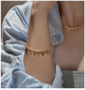 Detail of S925 sterling silver beaded necklace with dangling LUCKY letter pendants