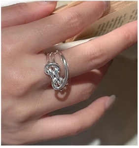 Detail shot of a knotted S925 sterling silver ring with textured twist design on a hand