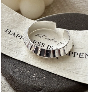 Macro shot of silver ring with wavy texture and adjustable open band design