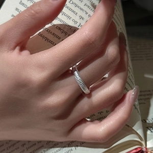 Bague élégante en argent sterling S925 à texture spirale mate sur fond de livre ancien