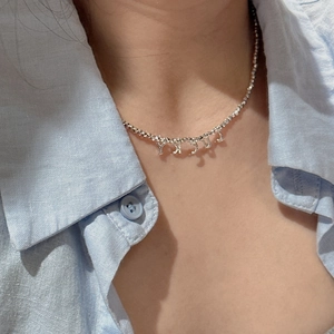 Collier en perles d'argent S925 minimaliste avec pendentif LUCKY porté par un mannequin