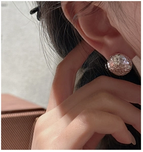 Detail of S925 sterling silver round stud earrings with shimmering glitter texture