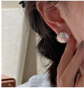 Close-up of S925 sterling silver ball earrings with crushed ice texture on a model's ear