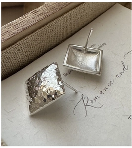 Macro shot of S925 sterling silver square stud earrings with hammered texture finish