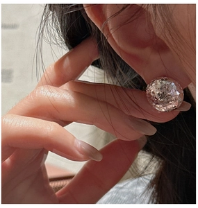 Macro shot of S925 silver round stud earrings with sparkling champagne glitter finish