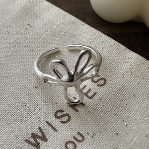 S925 sterling silver floral ring with adjustable open design on elegant beige fabric
