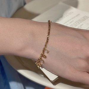 S925 silver beaded lucky letter bracelet with shiny gold finish on a soft background