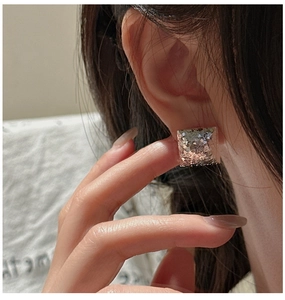 Detail of S925 silver square stud earrings with textured crushed ice surface on ear