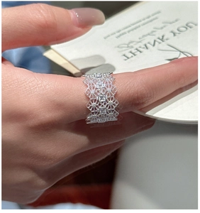 Macro detail of silver lace镂空 ring featuring geometric patterns and square zircon inlay
