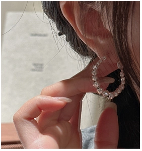 Gros plan de boucles d'oreilles C en argent S925 avec perles laser sur l'oreille