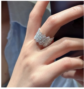 Detail of vintage silver lace hollow ring with square zircon stones and wavy edges