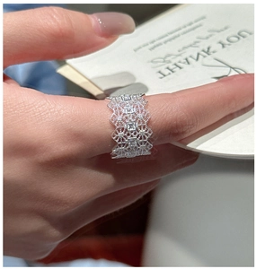 Macro shot of wide openwork lace S925 silver ring with sparkling cubic zirconia stones