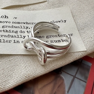 Minimalist S925 sterling silver multi-layer knotted open ring on a beige linen background