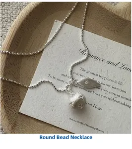 Close-up of S925 silver bead chain featuring star-engraved ball and zircon leaf charm