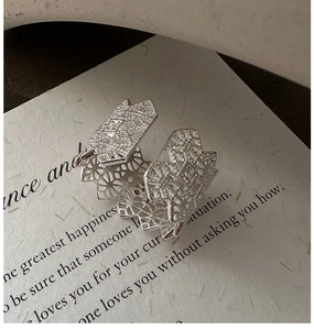 Close-up of S925 sterling silver ring featuring intricate lace texture on paper