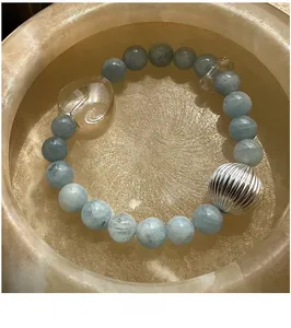 Détail d'un bracelet élastique en perles d'aigue-marine avec perles cœur en argent