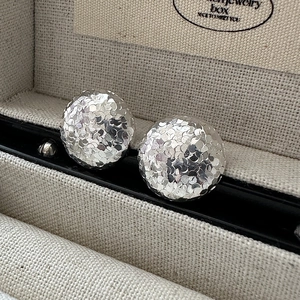 S925 sterling silver faceted disco ball stud earrings on a textured jewelry box display
