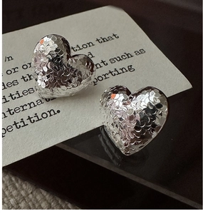 Macro shot of silver S925 heart earrings featuring a unique hammered crushed ice texture