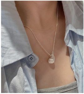 Detail of S925 sterling silver ball necklace with translucent pendant on female neck