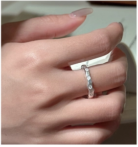 Détail de la bague ondulée en argent S925 avec zircons scintillants portée au doigt