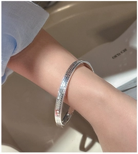 Macro detail of 925 sterling silver bangle featuring a textured honeycomb geometric pattern