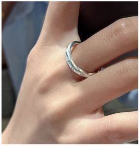 Détail d'une bague vague en argent S925 sertie de zircons portée sur la main