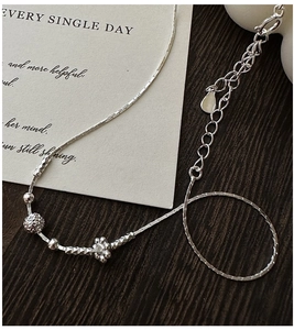 Dettaglio della collana in argento S925 con perline, ciondolo a fiore e maglia a serpente