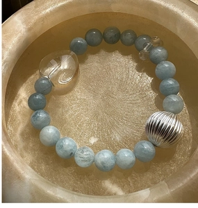 Gros plan détaillé du bracelet en perles d'argent S925 avec breloque cœur et pierres bleues