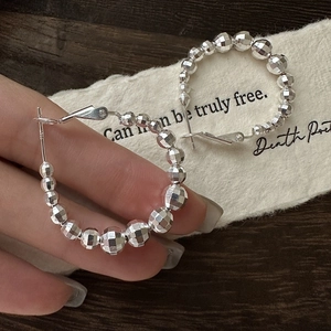 Créoles en argent sterling S925 avec perles à facettes laser sur papier blanc