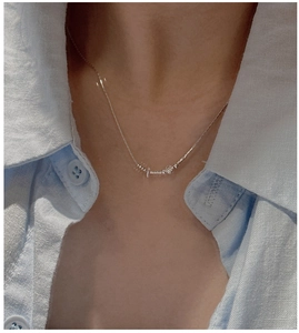 Dettaglio della collana di perle in argento S925 su una modella con camicia blu