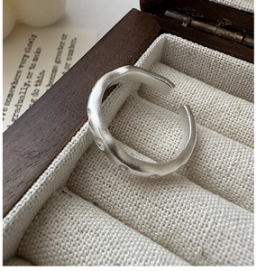 Détail de la bague S925 en argent sterling mat au design ondulé sur support velours