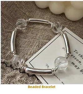 Detail of silver beaded bracelet with clear threaded beads on rustic linen fabric
