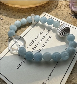 Gros plan sur un bracelet en argent S925 avec pierres d'aigue-marine et perle de cœur